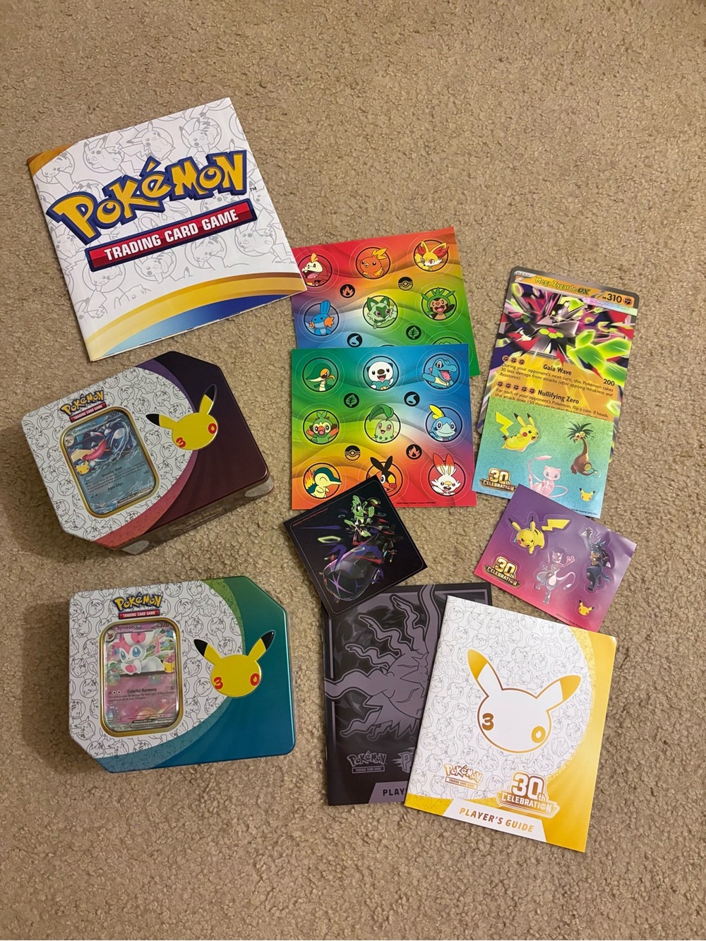 Pokemon 30th anniversary tin and promo, and various stickers and player’s guide
